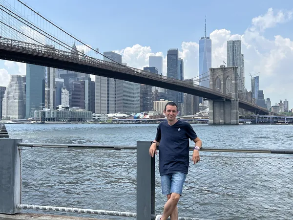 Salvador Salas in Brooklyn, with the Brooklyn Bridge and Manhattan behind him